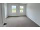Bedroom featuring neutral carpet and two bright windows with a view at 2411 Whitewing Ln, Wendell, NC 27591