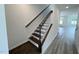 A modern staircase boasts hardwood steps and white railings, adding a touch of elegance to the home's interior at 2411 Whitewing Ln, Wendell, NC 27591