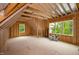Unfinished attic space with exposed wooden beams and two windows offering views at 2617 Packhouse Rd, Zebulon, NC 27597