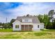 Exterior view of the back of a light gray house with a screened porch and a grassy yard at 2617 Packhouse Rd, Zebulon, NC 27597