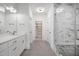 Bright bathroom showcasing a marble shower with a glass enclosure, dual sinks, and tile flooring at 2617 Packhouse Rd, Zebulon, NC 27597