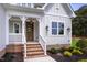 Inviting front porch with a modern, multi-paned door, brick steps and crisp white railing at 2617 Packhouse Rd, Zebulon, NC 27597