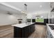 Modern kitchen featuring a central island with white countertop, flowing into an open floor plan at 2617 Packhouse Rd, Zebulon, NC 27597