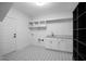 Well-lit laundry room featuring patterned flooring, storage shelves, and a modern sink and countertop at 2617 Packhouse Rd, Zebulon, NC 27597
