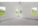 Bright main bedroom with large windows, neutral carpet, and elegant tray ceiling with fan at 2617 Packhouse Rd, Zebulon, NC 27597