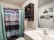 Bathroom featuring a tub, shower with purple and blue curtain, and mounted shelving at 304 Anaconda Trl, Mebane, NC 27302