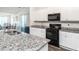 Bright kitchen featuring granite counters, white cabinets, and stainless steel appliances at 304 Anaconda Trl, Mebane, NC 27302