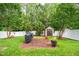 A large, grassy backyard features a grill, shed, and privacy fence at 313 Weeping Willow Dr, Durham, NC 27704