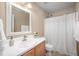 Bright bathroom with a white vanity, framed mirror, and a shower with a curtain at 313 Weeping Willow Dr, Durham, NC 27704