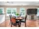 Cozy dining area featuring a wood table set for four, with bright windows and a view of the backyard at 313 Weeping Willow Dr, Durham, NC 27704