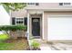 Close up view of front door with manicured shrubs and two-car garage at 313 Weeping Willow Dr, Durham, NC 27704