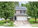 Two-story home with a two-car garage, well-manicured lawn, and mature trees at 313 Weeping Willow Dr, Durham, NC 27704