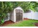 A useful garden shed with locking doors sits in a wooded backyard with a privacy fence at 313 Weeping Willow Dr, Durham, NC 27704