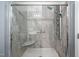 Modern shower with gray tiling, a glass door, and an adjustable shower head at 313 Weeping Willow Dr, Durham, NC 27704