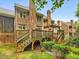 Back exterior view of brick home with multiple decks and staircases leading to a landscaped backyard with mature trees at 3347 Ridgecrest Ct, Raleigh, NC 27607