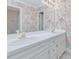 Bathroom featuring double sinks, white cabinets, granite counters, and wallpaper at 3347 Ridgecrest Ct, Raleigh, NC 27607