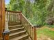 Wood deck stairs leading to a lush green backyard surrounded by mature trees offering a private outdoor space at 3347 Ridgecrest Ct, Raleigh, NC 27607