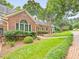 Charming brick home featuring a landscaped front yard and a welcoming brick pathway to the front door at 3347 Ridgecrest Ct, Raleigh, NC 27607
