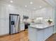 Modern kitchen with stainless steel appliances, white cabinets, granite countertops, and hardwood floors at 3347 Ridgecrest Ct, Raleigh, NC 27607