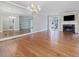 Cozy living room with fireplace, television, chandelier, hardwood floors and mirrored wall at 3347 Ridgecrest Ct, Raleigh, NC 27607