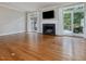 Open living room has hardwood floors, fireplace with mantle, and glass doors to the backyard at 3347 Ridgecrest Ct, Raleigh, NC 27607