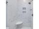 Luxurious shower featuring marble-patterned tiles and built-in shelves at 3347 Ridgecrest Ct, Raleigh, NC 27607