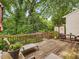 Spacious wooden deck with outdoor seating, plants, and wooded views perfect for outdoor dining and relaxation at 3347 Ridgecrest Ct, Raleigh, NC 27607