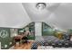 A cozy attic bedroom with a desk, comfortable bed, and interesting design elements at 3541 E Jameson Rd, Raleigh, NC 27604