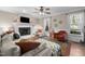Cozy living room features a painted fireplace, plush sofa, and abundant natural light from bright windows at 3541 E Jameson Rd, Raleigh, NC 27604