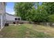 Landscaped backyard featuring a wooden fence, mature trees, and an outdoor dining area at 4001 Bostwyck Dr, Fuquay Varina, NC 27526
