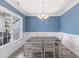 Formal dining room with decorative molding, a chandelier, a large window, and neutral colored wood floors at 4001 Bostwyck Dr, Fuquay Varina, NC 27526
