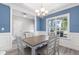Formal dining room featuring wainscoting, a modern chandelier, and a large window at 4001 Bostwyck Dr, Fuquay Varina, NC 27526
