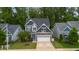 Charming two-story home featuring a stone accents, manicured lawn, and a welcoming turquoise-colored front door at 4001 Bostwyck Dr, Fuquay Varina, NC 27526