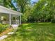 Manicured backyard with covered back porch, swing set, and tree house at 4112 Rowan St, Raleigh, NC 27609