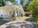 Exterior of white brick home with brick chimney, covered driveway, and woodpile at 4112 Rowan St, Raleigh, NC 27609