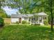 View of house with well maintained lawn, deck with dining area and patio seating at 4112 Rowan St, Raleigh, NC 27609