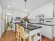 Updated kitchen with white cabinets, a center island with seating, and modern pendant lighting at 4112 Rowan St, Raleigh, NC 27609