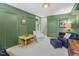 Cozy living room with green walls, a comfortable armchair, and a table and chairs at 4112 Rowan St, Raleigh, NC 27609