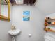 Small powder room with a pedestal sink and an unframed mirror with white walls and open shelving at 4112 Rowan St, Raleigh, NC 27609