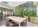 Wooden back deck with dining table, ceiling fan and view of the backyard and wooded area at 4412 Thistlehill Ct, Raleigh, NC 27616