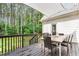 A wooden back deck with dining table and view of the backyard and wooded area at 4412 Thistlehill Ct, Raleigh, NC 27616