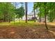 Tree-filled backyard showing a home's exterior nestled within a private, wooded landscape at 4412 Thistlehill Ct, Raleigh, NC 27616