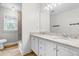 Bright bathroom featuring a dual sink vanity with granite countertops, wood look flooring, and a shower at 4412 Thistlehill Ct, Raleigh, NC 27616