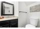 Bathroom with granite vanity, white toilet, and decor including a wood sign at 4412 Thistlehill Ct, Raleigh, NC 27616
