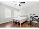 Sunlit bedroom with wood floors, two windows, and neutral decor; featuring a ceiling fan at 4412 Thistlehill Ct, Raleigh, NC 27616
