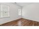 Bright bedroom featuring hardwood flooring and two windows with white trim at 4412 Thistlehill Ct, Raleigh, NC 27616