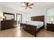 Spacious bedroom with hardwood floors, ceiling fan and a large wooden bed frame with matching dresser at 4412 Thistlehill Ct, Raleigh, NC 27616