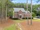 Elegant brick home featuring lush landscaping, a well-manicured lawn, and a welcoming entrance at 4412 Thistlehill Ct, Raleigh, NC 27616