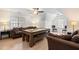 Spacious game room with a pool table, cozy couches, and bright natural light from the windows at 4412 Thistlehill Ct, Raleigh, NC 27616