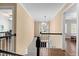 Bright hallway with hardwood floors and view of large arched window with hanging light fixture at 4412 Thistlehill Ct, Raleigh, NC 27616